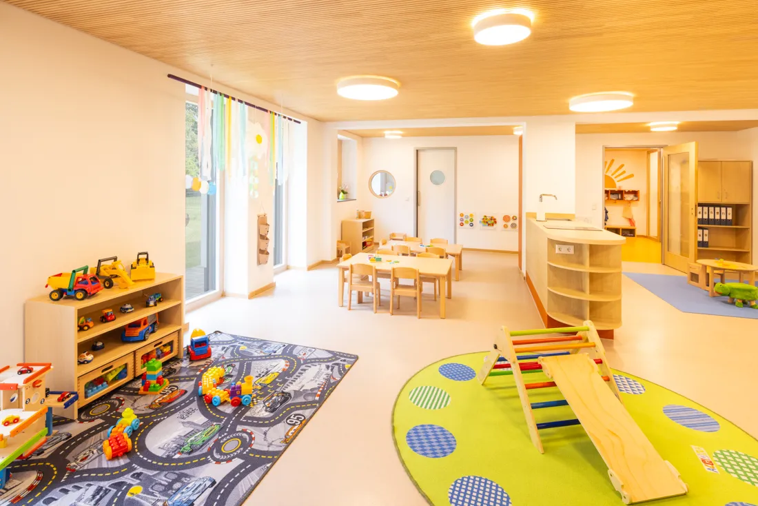 Bunter Gruppenraum mit viel natürlichem Licht und Spielzeugen