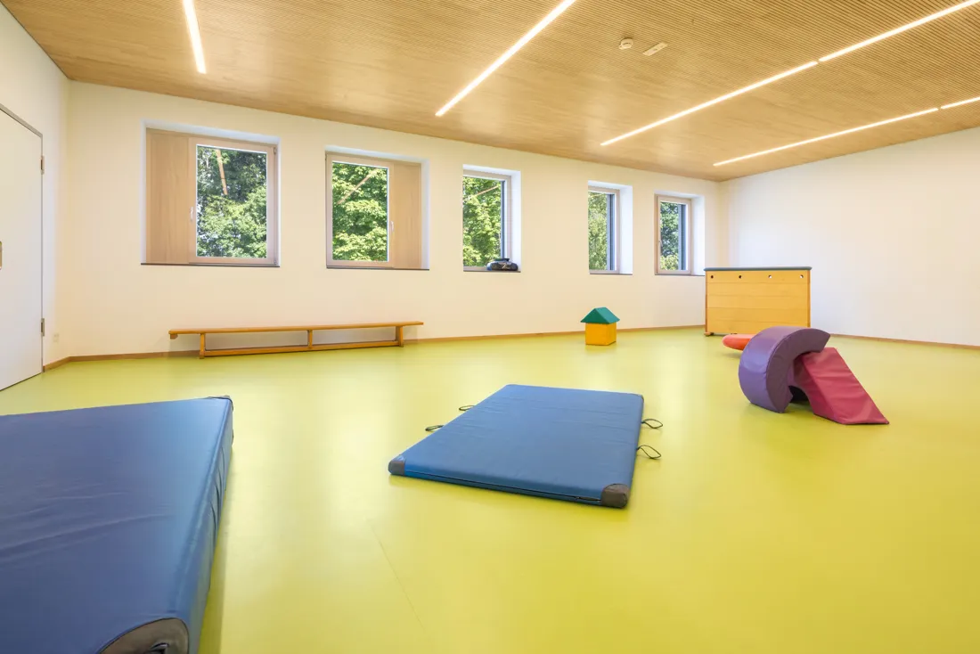 Turnhalle mit grünem Boden, Matten und Schaumstoffspielzeug zum Spiel und Sport